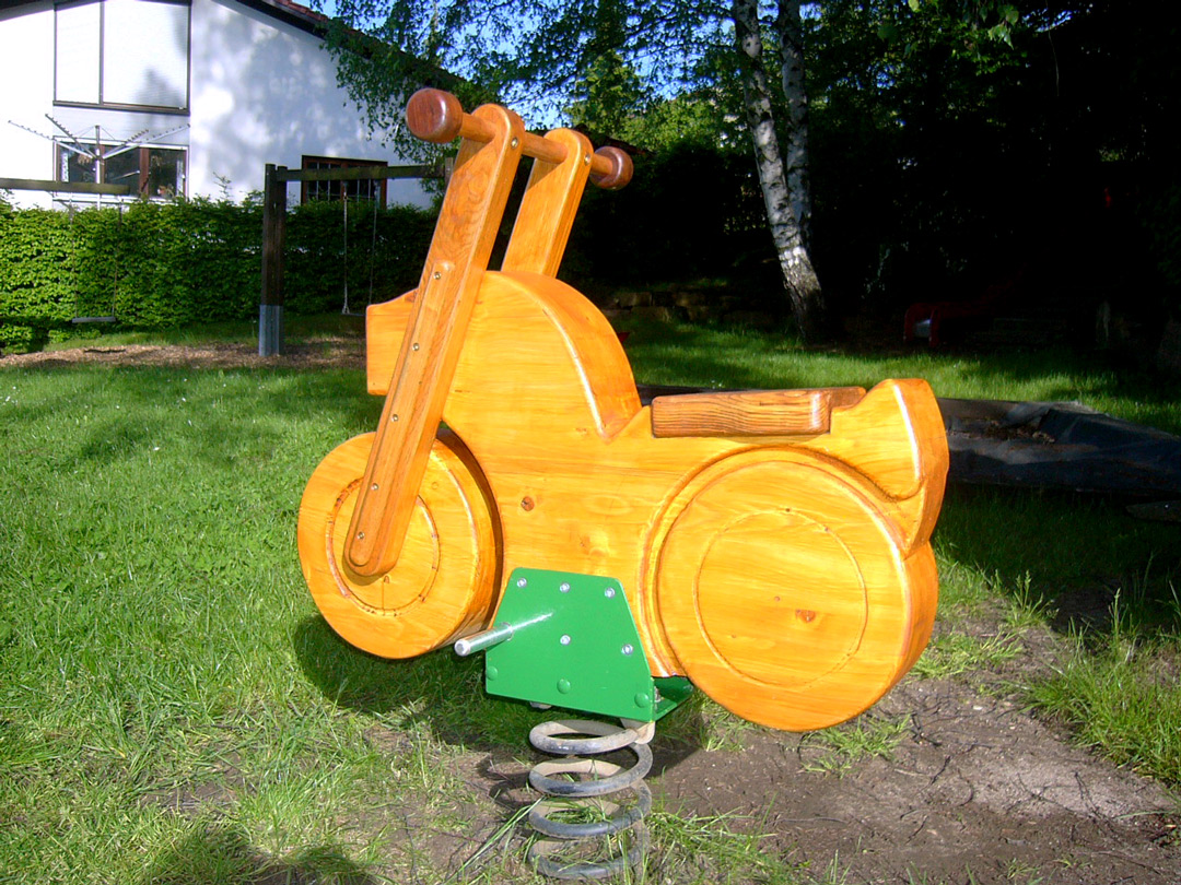 Holzmotorrad auf einem Spielplatz